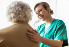 Friendly nurse supporting an elderly lady