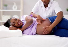 A pregnant woman receiving a massage from their therapist.