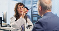 A medical professional examines a patient's reaction to light for pupil response during concussion assessment.