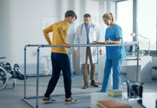 Strong Patient with Injury Making First Steps, Walks Holding for Parallel Bars.