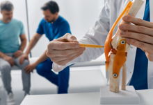 Adult man with knee injury during consultation with doctor traumatologist at medical clinic
