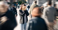 An anxious woman in a crowd of people in street