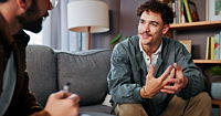 A therapist and a man are discussing mental health advice or support in an office.