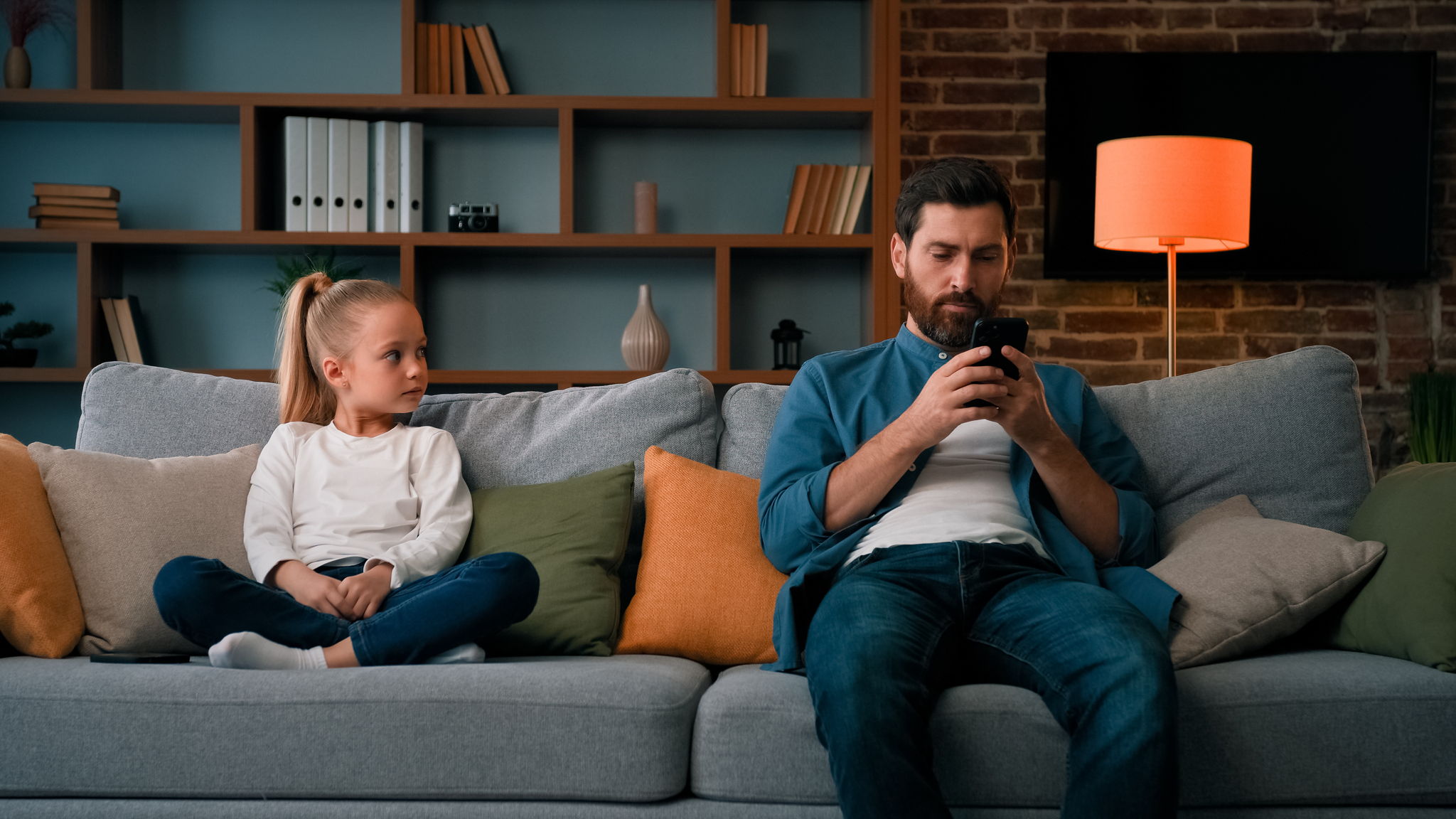 A child in need of attention is ignored by their phone addicted parent.