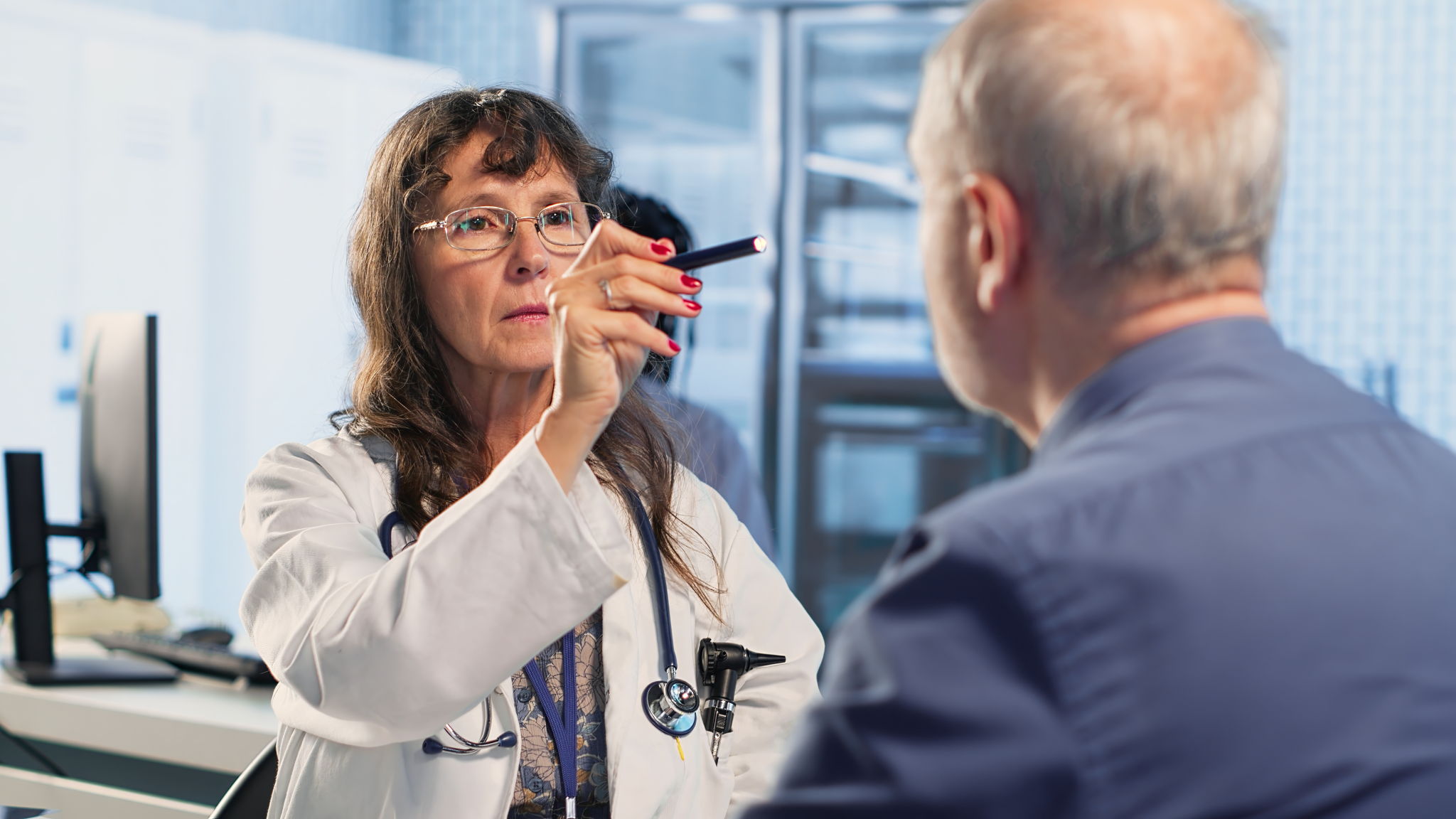 A medical professional examines a patient's reaction to light for pupil response during concussion assessment.