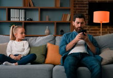 A child in need of attention is ignored by their phone addicted parent.