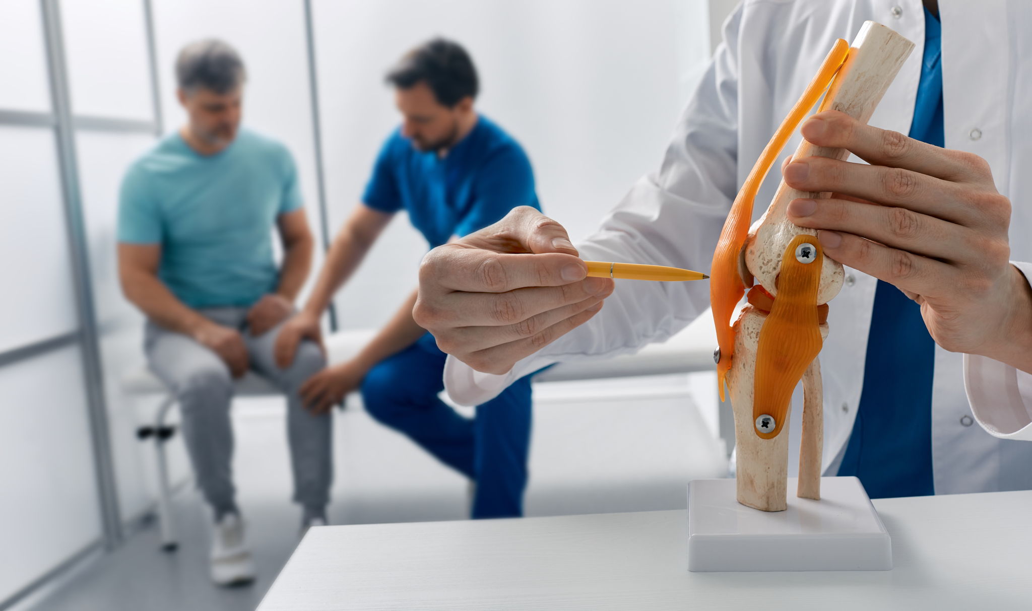 Adult man with knee injury during consultation with doctor traumatologist at medical clinic
