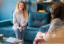 Happy red-haired woman talking to a female psychologist. Discusses her problems, mental trauma.