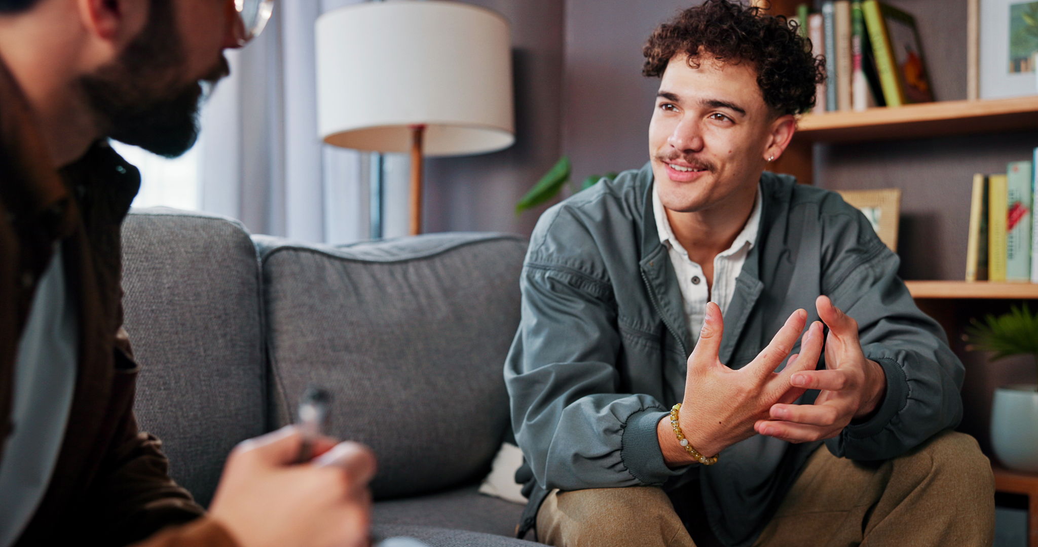 A therapist and a man are discussing mental health advice or support in an office.